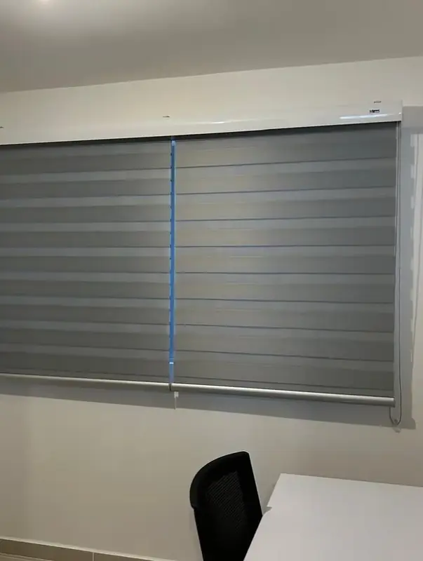 Grey day-and-night blind in a home office