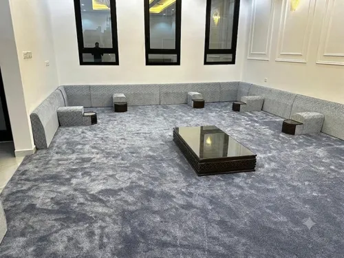 Grey wall-to-wall carpet fitted in a majlis with floor seating