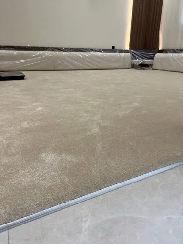 Clean carpet edge finished against a marble floor